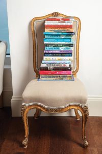 An antique chair holds some of the couple’s books. Photo by Benjamin Rusnak