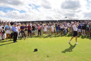 Justin Thomas tees off as Jack Nicklaus (far left) and spectators look on. Photo by Jim Mandeville_Nicklaus Designs