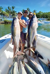 Riley Linden (right), Mike Linden (center), and Riley’s friend Billy George (left) show off their yellowfin tuna catches. Photo by George LaBonte